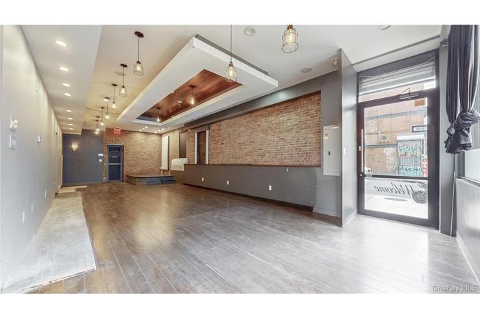 Community lobby featuring brick wall, recessed lighting, and electric panel