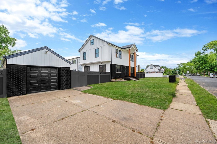 View of side of property featuring an outdoor structure, driveway, and a detached garage
