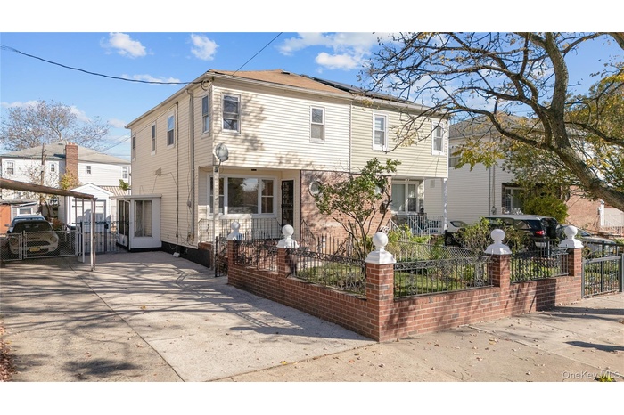 View of front of house featuring a fenced front yard, a gate, roof mounted solar panels, and driveway