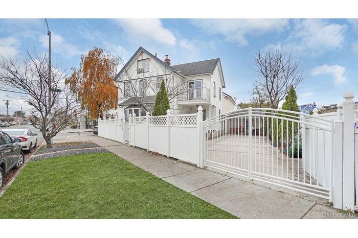 View of home's exterior featuring a fenced front yard, a chimney, a gate, a balcony, and a shingled roof