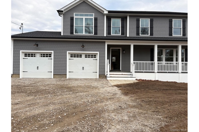 View of front facade with a porch and driveway