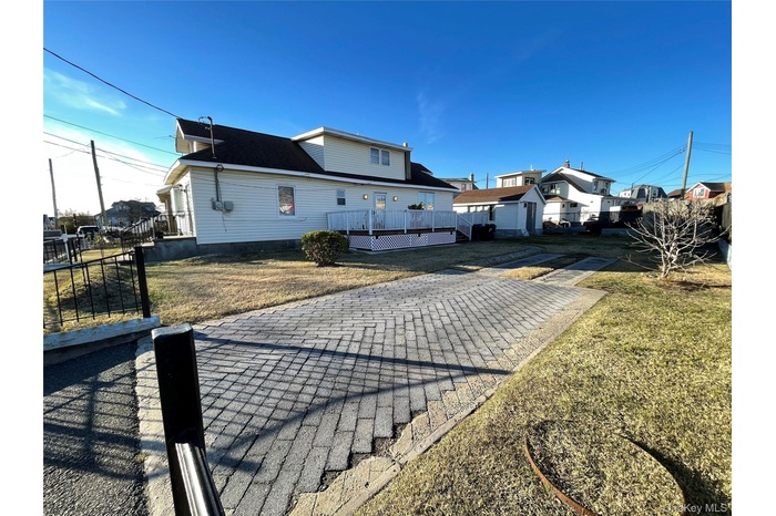 Back of house featuring a deck, a yard, and a patio