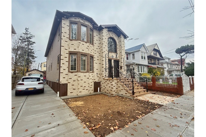 View of front of home with driveway, brick front and a residential view