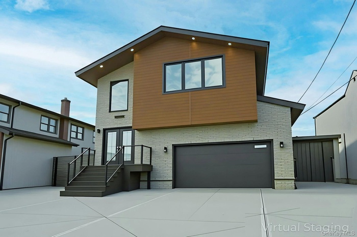 View of front of property with a garage, brick siding, and concrete driveway