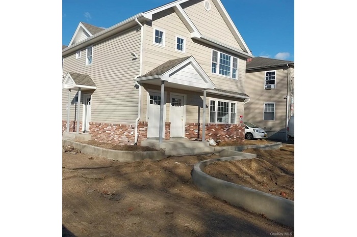 Traditional-style house with brick siding and a shingled roof