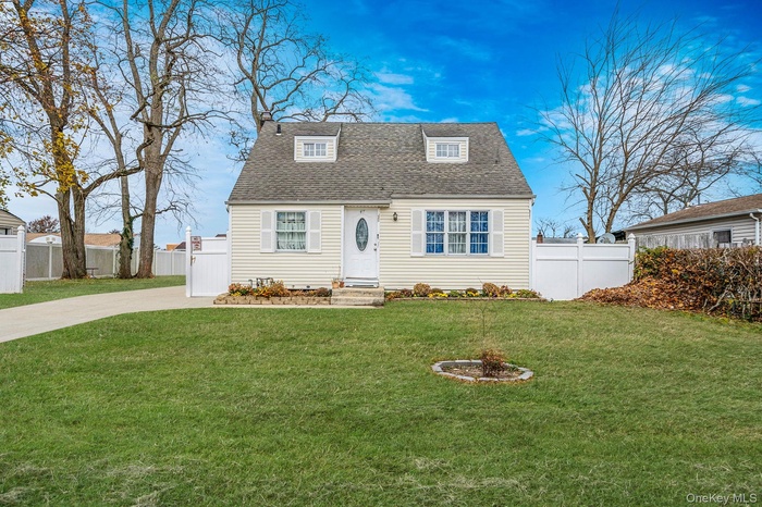 Cape cod home featuring roof with shingles and concrete driveway