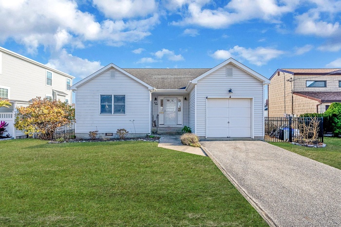 View of front facade featuring driveway, a garage, and a shingled roof