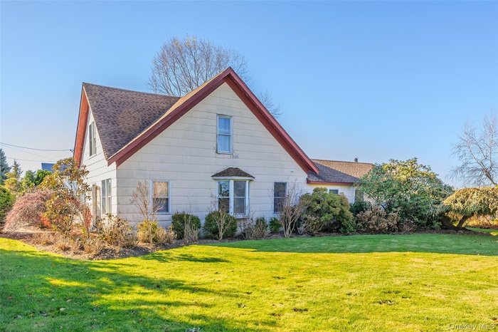 View of property exterior with a yard and a shingled roof