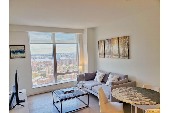 Living area with wood finished floors and a city view