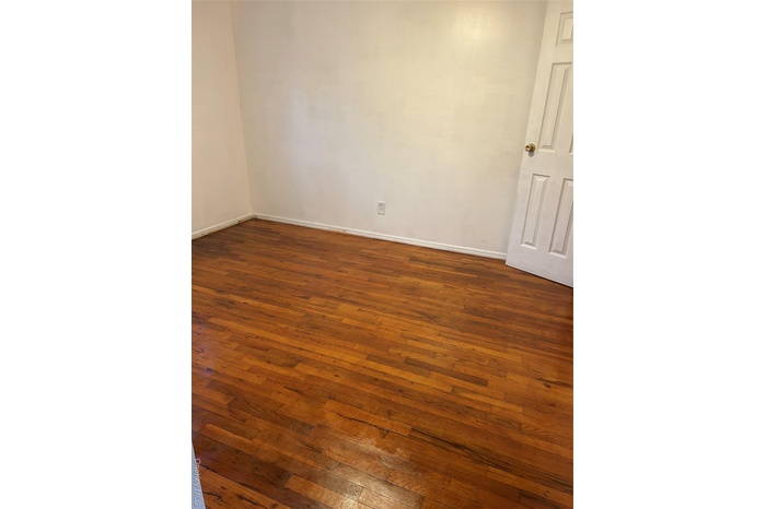 Empty room with dark wood-type flooring
