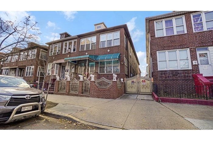 Traditional home featuring a gate and brick siding