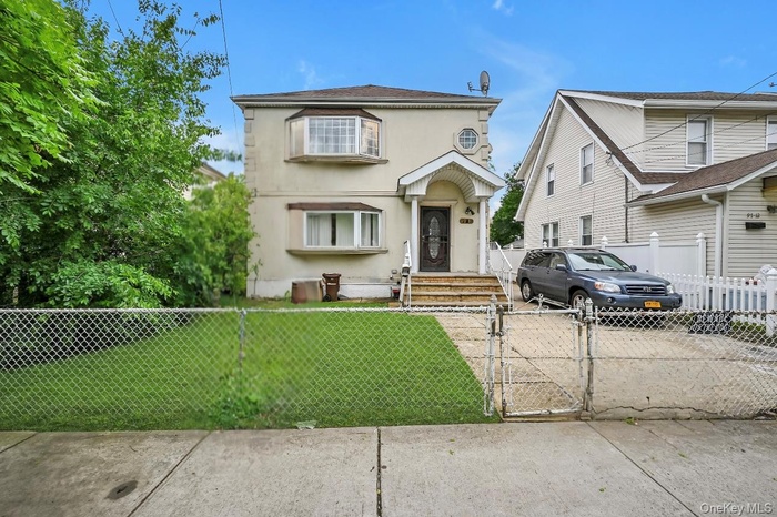 Traditional home featuring a gate and stucco siding