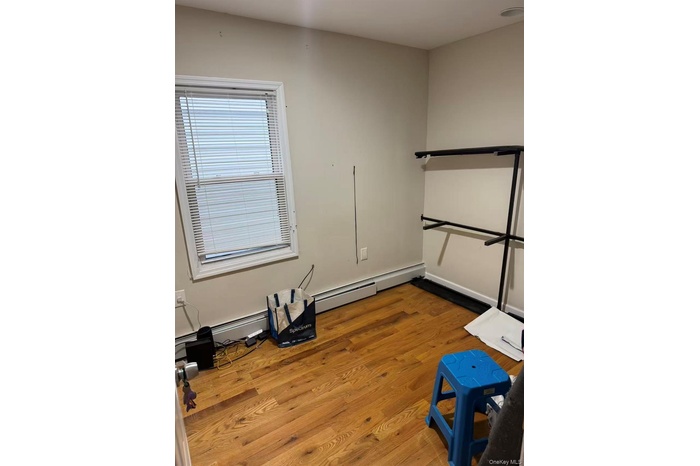 Spare room featuring light wood-style flooring and baseboard heating