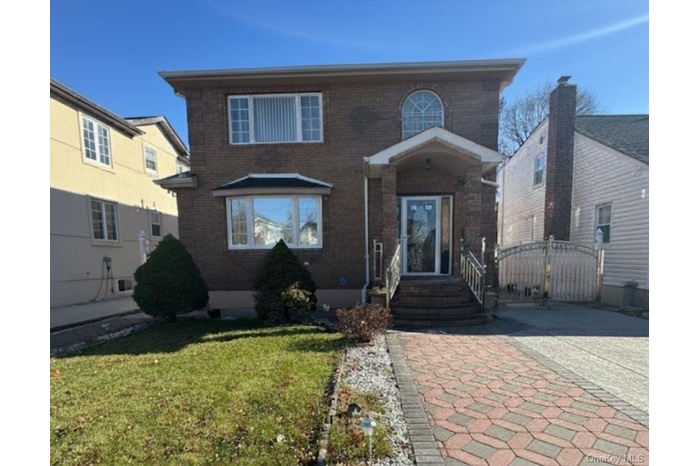 View of front of property with brick siding and a front lawn