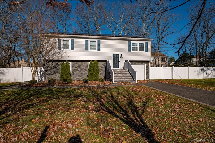 Bi-level home featuring asphalt driveway and an attached garage