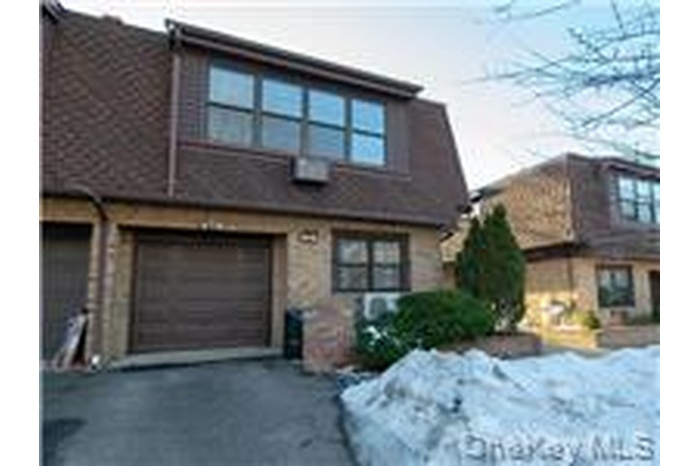View of front of house featuring an attached garage and asphalt driveway