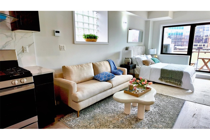 Bedroom featuring multiple windows, light wood-style flooring, and radiator
