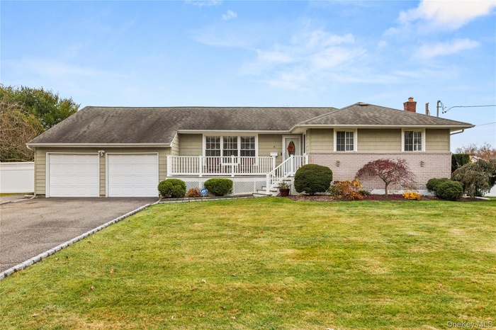 Ranch-style home featuring a front yard, a porch, a chimney, asphalt driveway, and a shingled roof