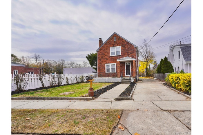 View of front facade with brick siding and a chimney