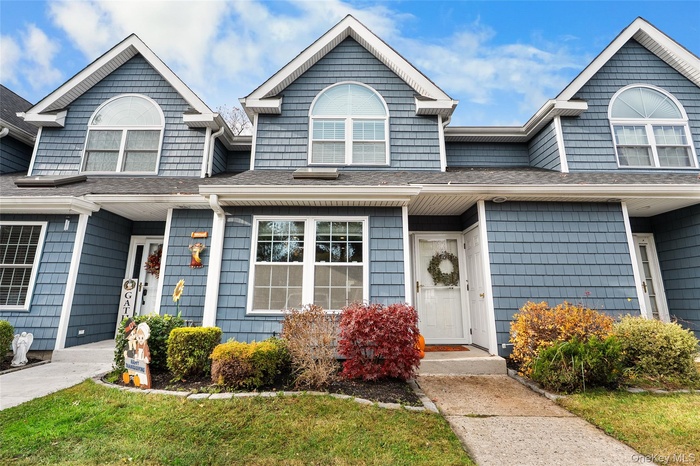 View of front facade with a shingled roof and a front yard