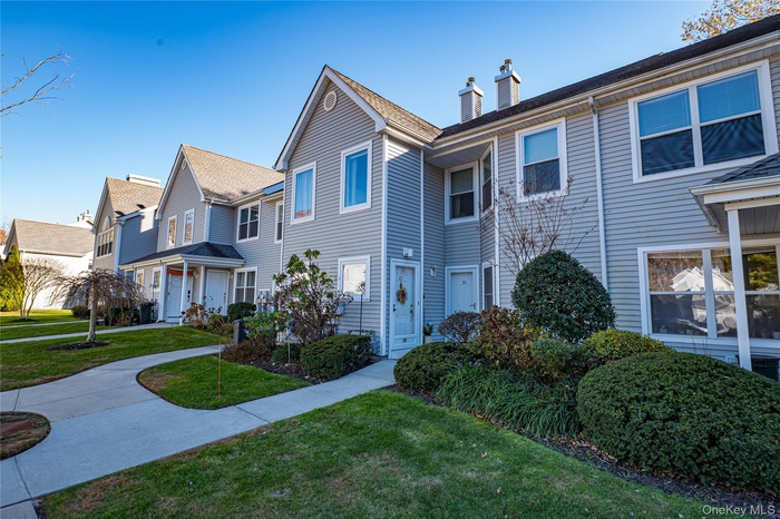Traditional home featuring a chimney, a front lawn, a residential view, and roof with shingles