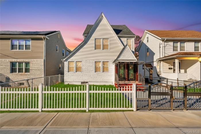 View of front of house featuring a fenced front yard and a gate