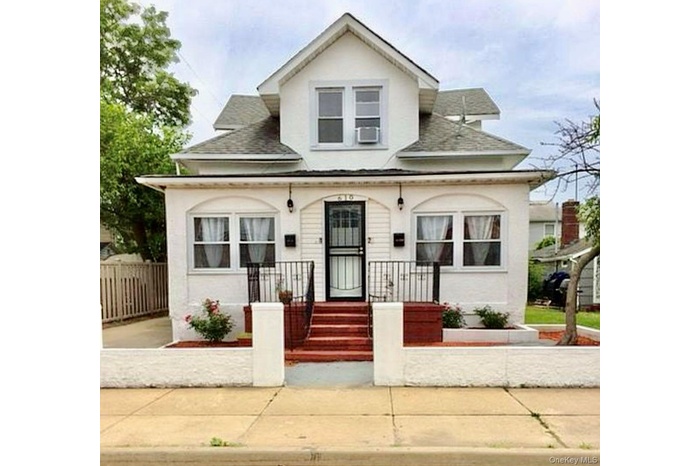Bungalow with a shingled roof and stucco siding