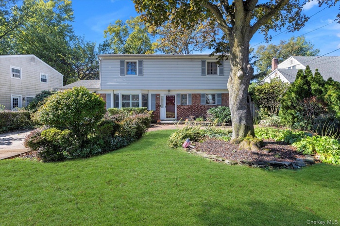 Colonial-style house with a front yard and brick siding