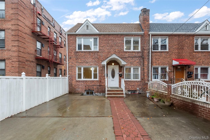Traditional-style house with a shingled roof, brick siding, and a chimney