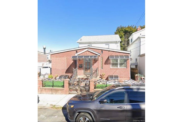 View of front of property featuring a fenced front yard, brick siding, and a gate
