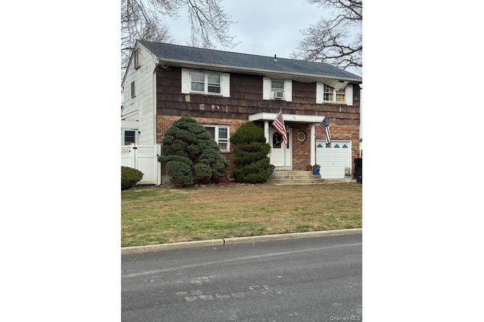 View of front of house with a garage and brick siding