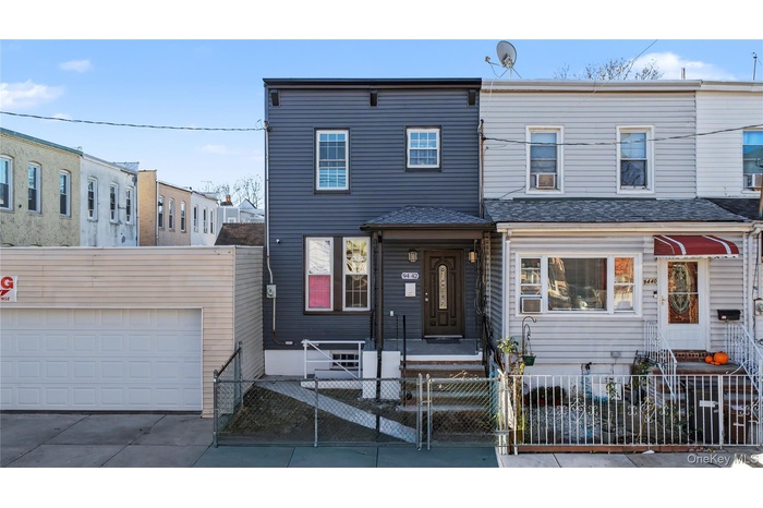 View of front facade featuring a fenced front yard, a gate, a garage, and concrete driveway