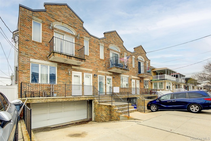 View of front of house featuring brick siding, a residential view, and a balcony