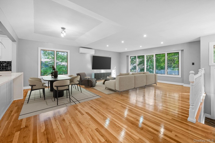 Dining area featuring light wood finished floors, healthy amount of natural light, a wall mounted AC, and recessed lighting