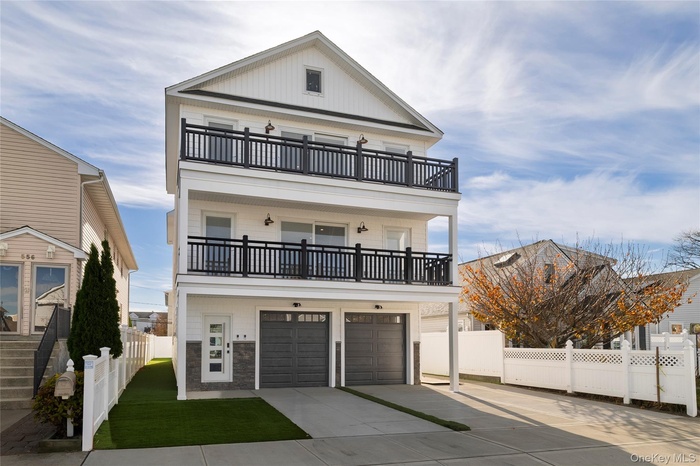 View of front of property with driveway, a garage, a balcony, and board and batten siding