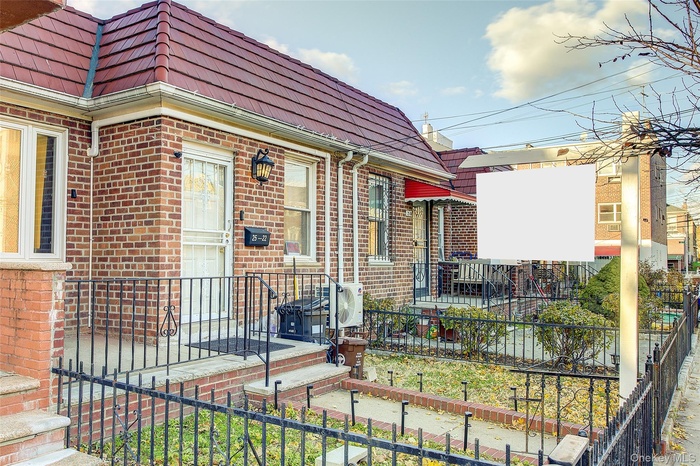 Doorway to property featuring brick siding and mansard roof