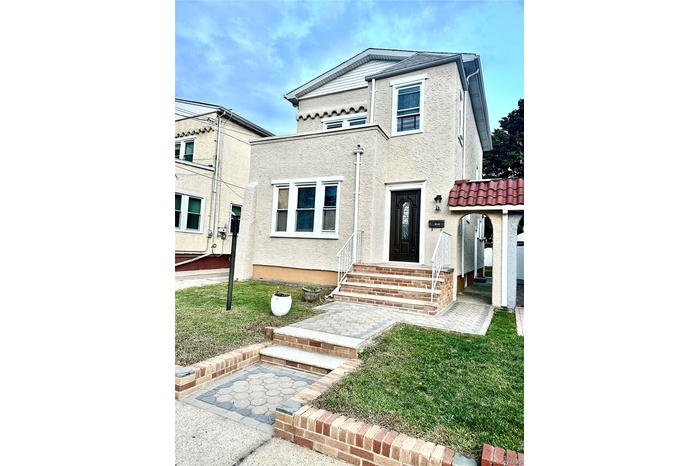 View of front facade featuring stucco siding and a front lawn