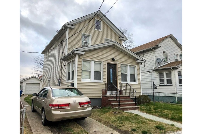 View of front of property with an outbuilding and a garage