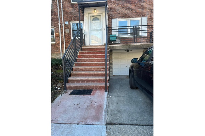Property entrance featuring brick siding and an attached garage