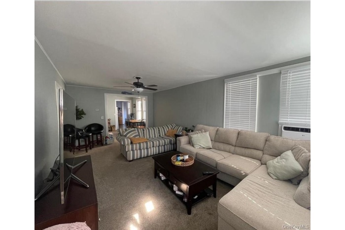 Living area featuring cooling unit and ceiling fan