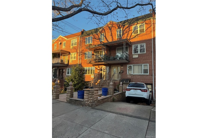 View of front of house featuring a balcony and brick siding