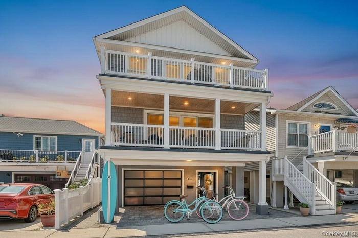 Beach home featuring stairs, a garage, and driveway