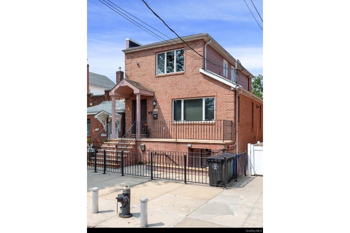 Traditional home with a fenced front yard, brick siding, and a gate