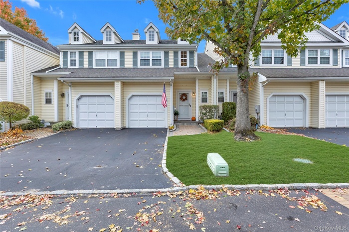 Front exterior of home featuring a front lawn, driveway, and a garage