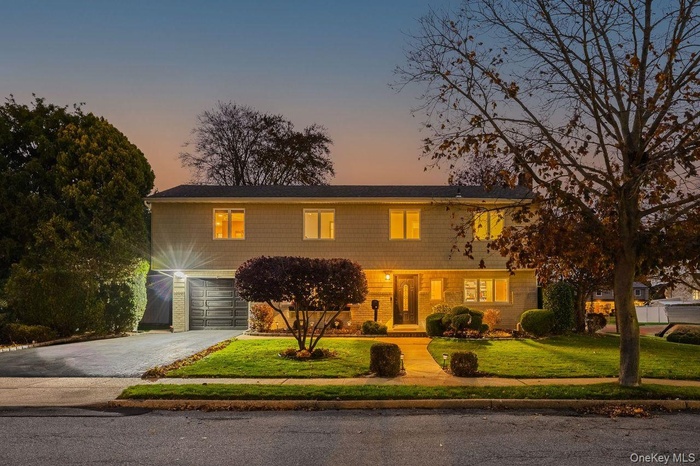 Colonial house featuring driveway, a yard, and a garage