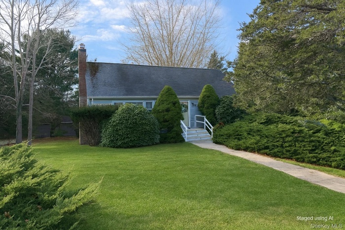 View of front facade with a front lawn, a chimney, and a shingled roof