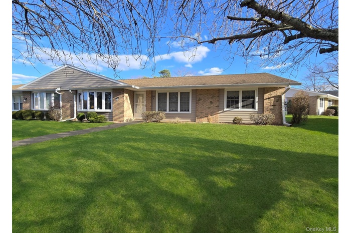 Ranch-style home with brick siding and a front lawn