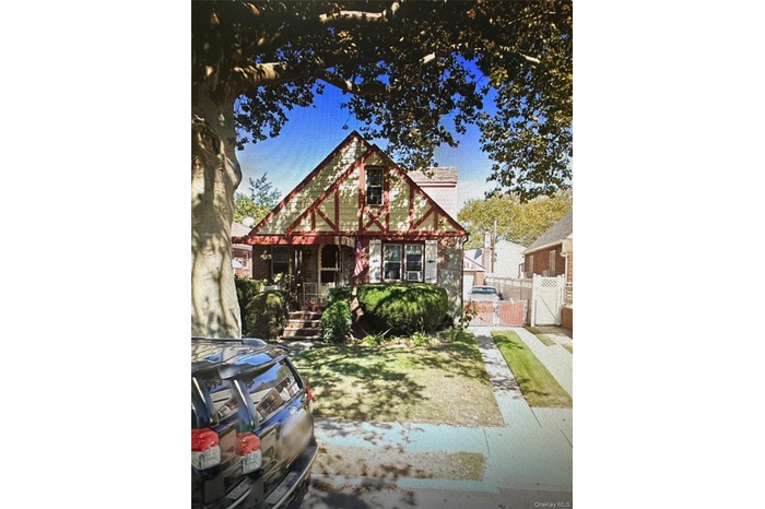 Tudor home with a gate and covered porch