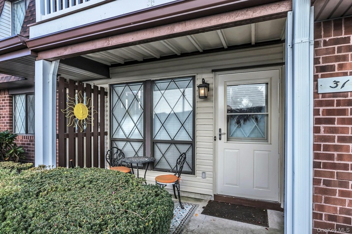 Doorway to property featuring brick siding