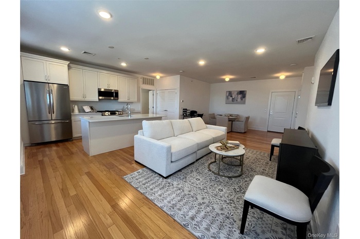 Living area featuring light wood finished floors and recessed lighting